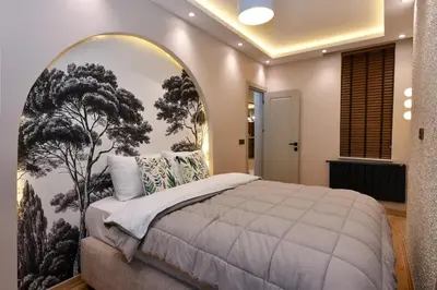 a bedroom with a large bed with a tree mural at chic ve modern daire taksim meydani in Istanbul