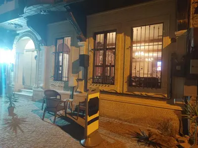 a room with a chair and a table and windows at Duru Hanım Konağı in Mudanya