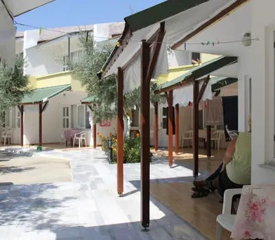 a woman sitting on a porch of a building at boncuk motel in Marmara