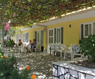 a group of people sitting outside of a building at boncuk motel in Marmara
