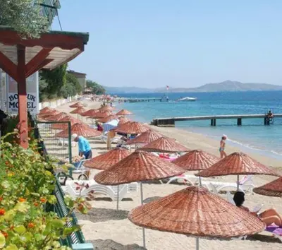 a group of umbrellas on a beach with the ocean at boncuk motel in Marmara