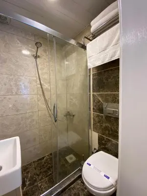 a bathroom with a toilet and a glass shower at Pera Standard Rooms in Istanbul