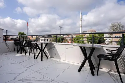 a balcony with tables and chairs on a building at Kemer City Hotel İstanbul Airport in Kemerburgaz