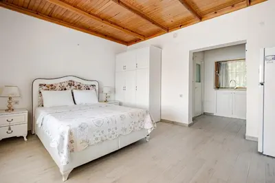 a white bedroom with a bed and a wooden ceiling at Marmara Yali Evi in Marmara