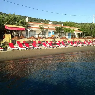 a group of chairs on a beach next to the water at Marmara Yali Evi in Marmara