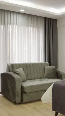 a living room with a couch in front of a window at Parna Sapanca Hotel in Sakarya
