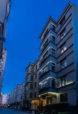 a tall apartment building in a city at night at Big Urban Taksim Terrace Stay in Istanbul