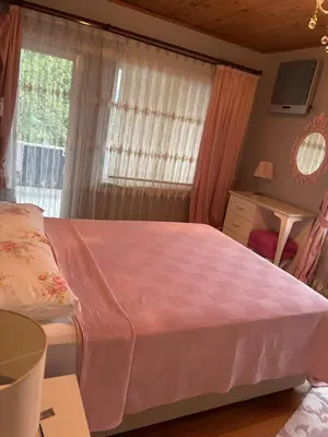 a bedroom with a pink bed and a window at Villa Denizci in Sapanca