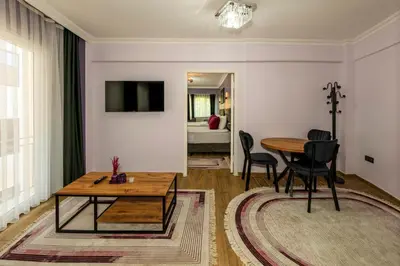 a living room with a wooden table and chairs at Cenova Suite Hotel in Istanbul