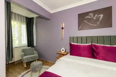 a bedroom with a large bed with purple walls at Cenova Suite Hotel in Istanbul
