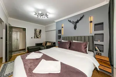 a bedroom with a large bed and a living room at Cenova Suite Hotel in Istanbul