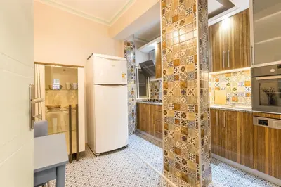 a kitchen with a refrigerator and a tile wall at Stylish 1BR with Prime Location and Bold Design in Istanbul
