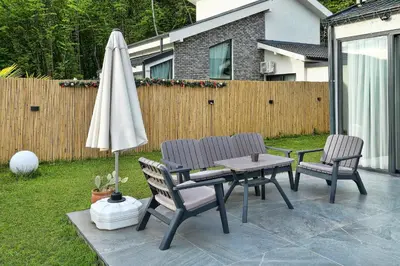 a patio with a table and an umbrella and chairs at New Balturk Nature Villas in Sapanca