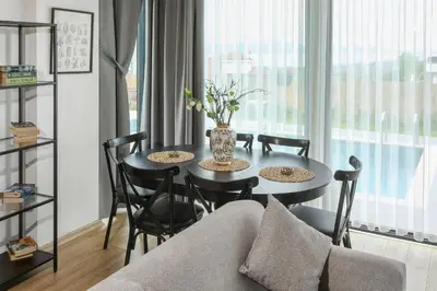 a living room with a table with chairs and a couch at New Balturk Nature Villas in Sapanca