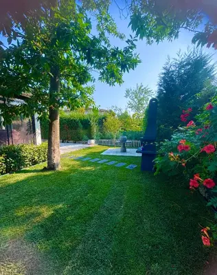 a park with a bench and a tree and flowers at Cadde Sapanca Sıcak Havuzlu Geniş Bahçeli in Sapanca