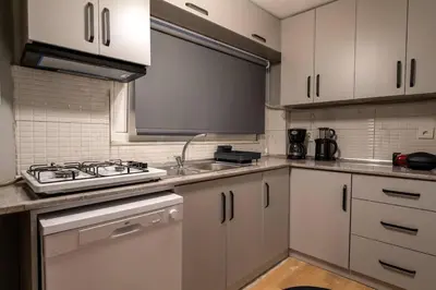 a kitchen with white cabinets and a stove top oven at Cozy and Modern 3BR with Private Patio in Beşiktaş in Istanbul