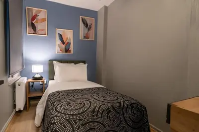 a small bedroom with a bed and paintings on the wall at Cozy and Modern 3BR with Private Patio in Beşiktaş in Istanbul