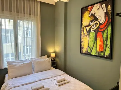 a bedroom with a bed with a painting on the wall at Elegant and Cozy 2BR with Balcony near Taksim in Istanbul