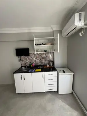 a small kitchen with white cabinets and a stove at Kaman Home Apart in Istanbul