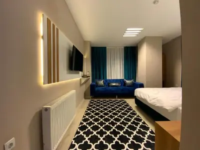 a hotel room with a bed and a blue couch at Lina Suit Hotel in Istanbul