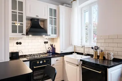 a kitchen with white cabinets and black counter tops at Cozy Flat with Balcony Near Istiklal Avenue in Istanbul