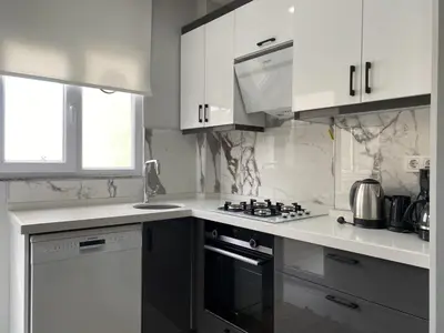 a kitchen with white cabinets and a stove top oven at Central Comfortable Flat in Historic Balat in Istanbul