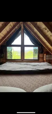 a bedroom with a large window in a attic at Galaxy Housing