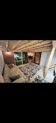 a living room with a couch and a brick wall at Galaxy Housing
