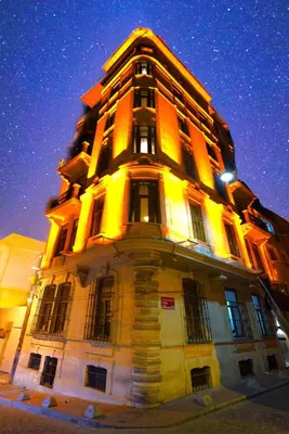 a tall building is lit up at night at Flex Pera in Istanbul