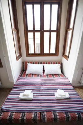 a bed in a room with a cat sitting on it at i1 Historic House Hotel with Gorgeous View in Istanbul