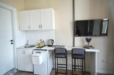a kitchen with white cabinets and a counter with stools at i1 Historic House Hotel with Gorgeous View in Istanbul