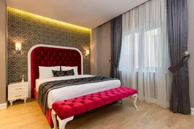 a bedroom with a red bed and a red bench at Dencity Hotels & Spa in Istanbul