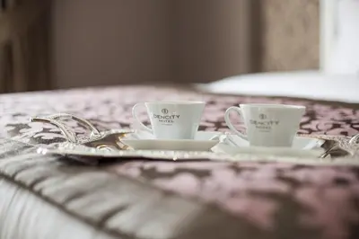 two coffee cups and saucers on a tray on a bed at Dencity Hotels & Spa in Istanbul