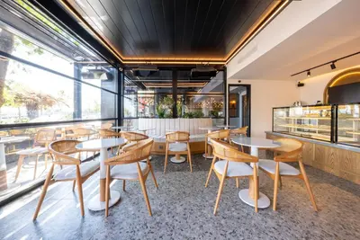 a restaurant with tables and chairs and a window at Premier Lounge Hotel in Tuzla