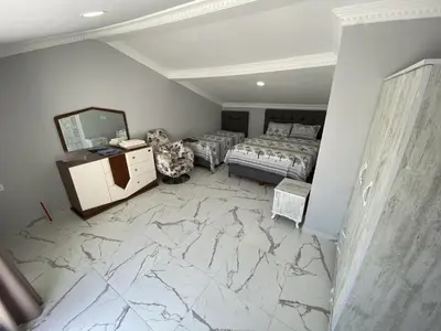 a bedroom with a marble floor with a bed and a mirror at Ege Naz Villa in Avsa Adasi