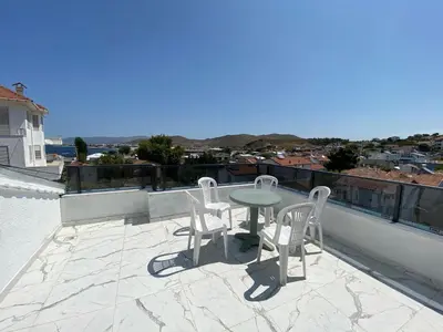a patio with a table and chairs on a roof at Ege Naz Villa in Avsa Adasi