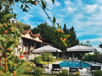a house with a swimming pool and umbrellas at Manzara Ödüllü Büyük Havuzlu Premium Villa in Dibektaş