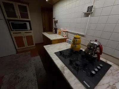 a kitchen with a stove with a tea kettle on it at Manzara Ödüllü Büyük Havuzlu Premium Villa in Dibektaş