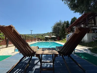 a pair of chairs sitting next to a swimming pool at Manzara Ödüllü Büyük Havuzlu Premium Villa in Dibektaş