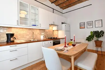 a kitchen with a wooden table and white cabinets at Charming Flat Retro Design AC Galata in Istanbul