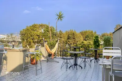 a patio with tables and chairs and a hammock at The Lumina Hotel in Istanbul