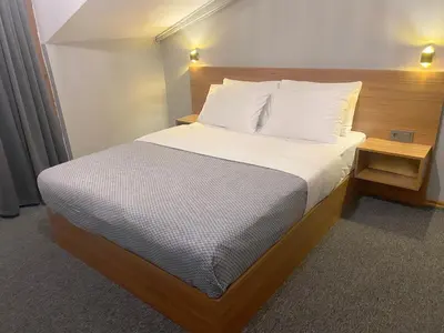 a bed with white sheets and pillows in a room at Rosse Hotel in Kırac