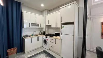 a kitchen with white cabinets and a refrigerator at Taksim Square Luxury 4BR Next to Hotels Perfect for Families & Groups in Istanbul