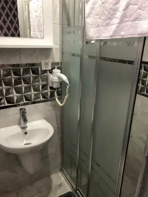 a bathroom with a shower with a sink and a shower at GOLD SARAY PANSİYOn in Saray