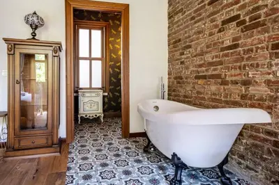 a bathroom with a white bath tub next to a brick wall at Chic 2BR Retreat House - Heart of Cihangir! #394 in Istanbul