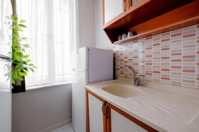 a kitchen with a sink and a white refrigerator at Chic Apartment Walk to Maçka Park Nişantaşı in Istanbul
