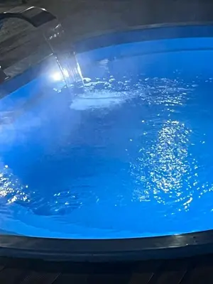 a pool of blue water with a water fountain at Sapancasadembungalov in Sapanca