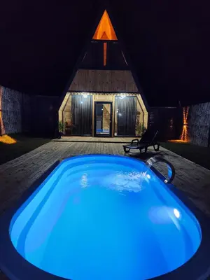 a blue hot tub in front of a house at night at Sapancasadembungalov in Sapanca