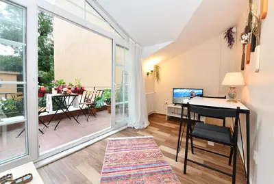 a living room with a desk and a balcony at Private Terrace AC Bright Flat Galata in Istanbul