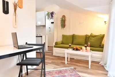 a living room with a couch and a table with a laptop at Private Terrace AC Bright Flat Galata in Istanbul